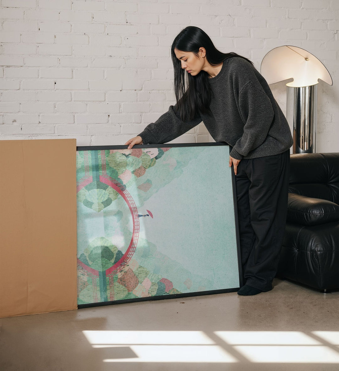 Woman unboxing a large artwork in a living room.