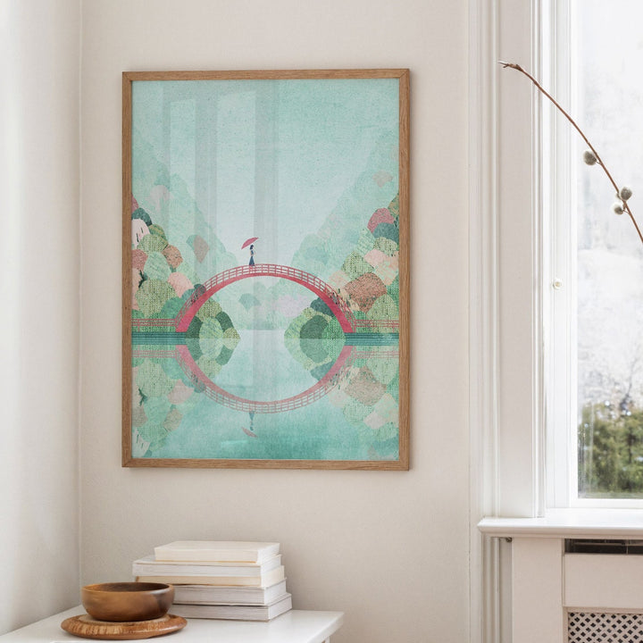 Artwork on a wall in a room with a window and small table.