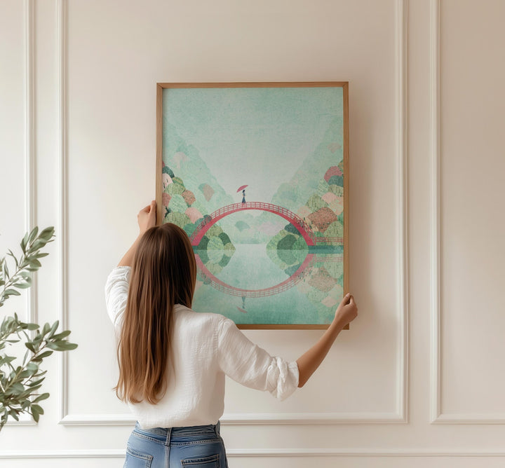 Woman hanging an artwork on a wall