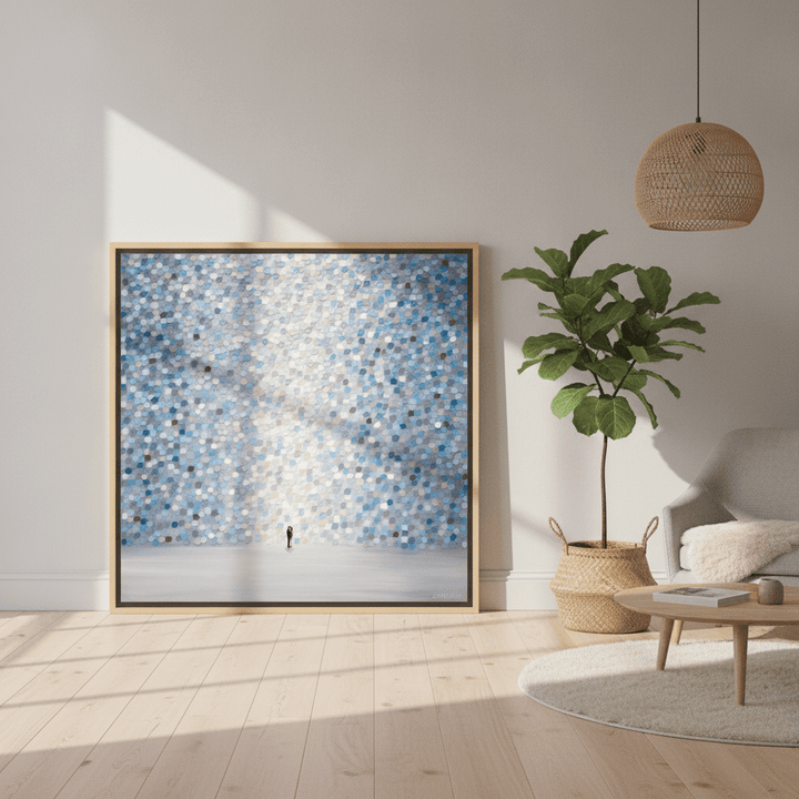 Oversized statement canvas wall art with a natural timber surround leaning against the wall in a bright Scandinavian living room