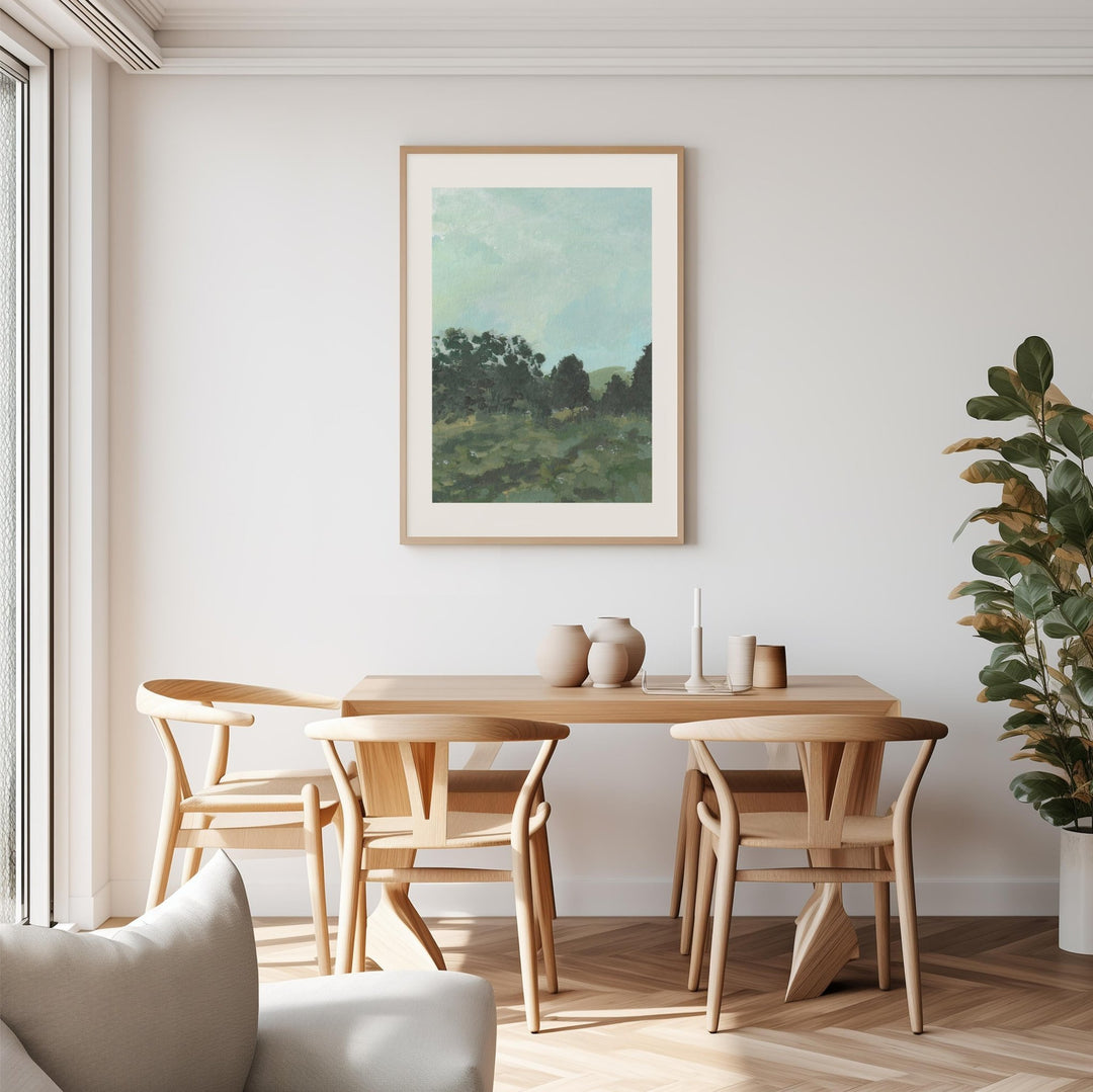 Dining room with wooden table and chairs, artwork on the wall, and a plant.