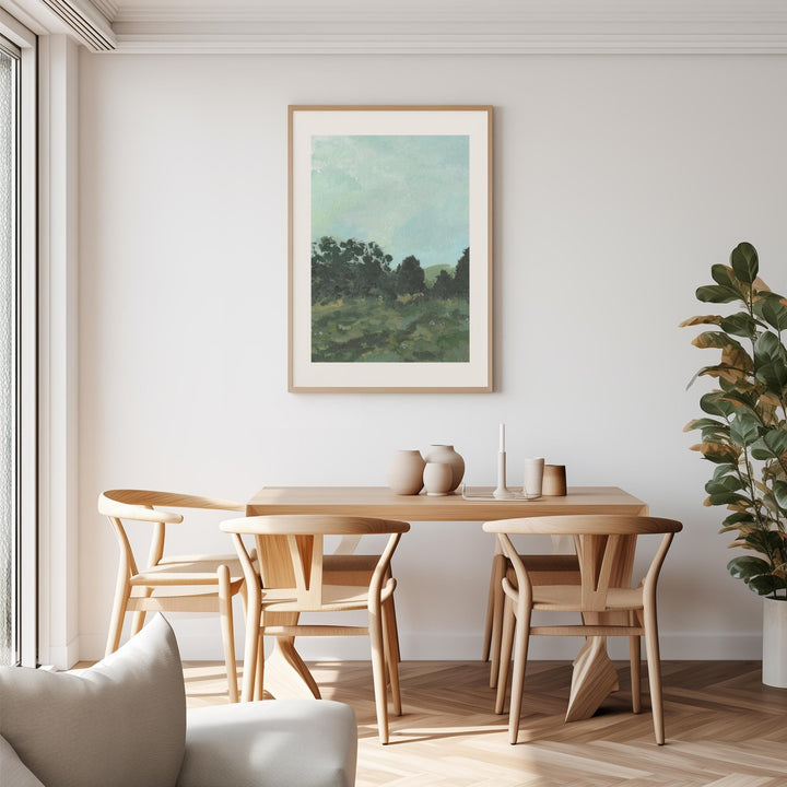 Dining room with wooden table and chairs, artwork on the wall, and a plant.