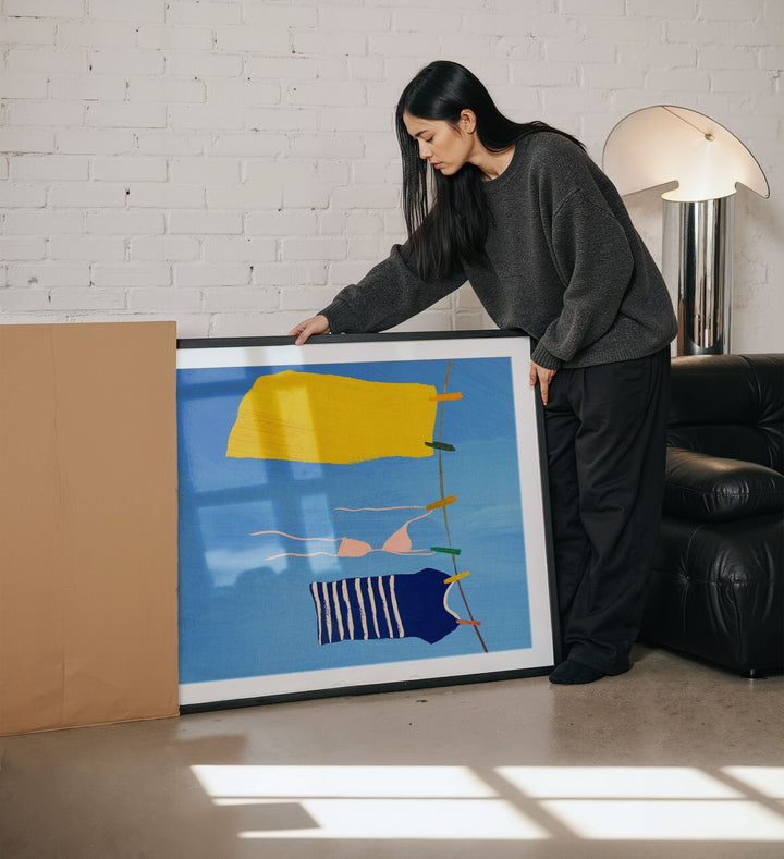 Woman holding an abstract art piece in a living room.