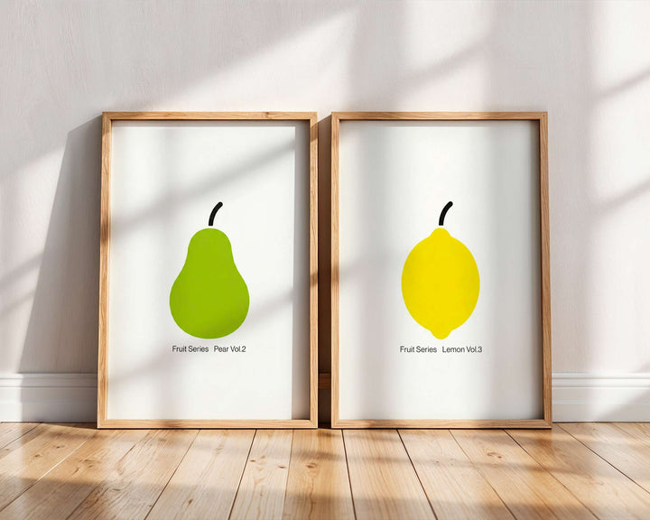 Two framed prints of a green pear and yellow lemon on a white wall.