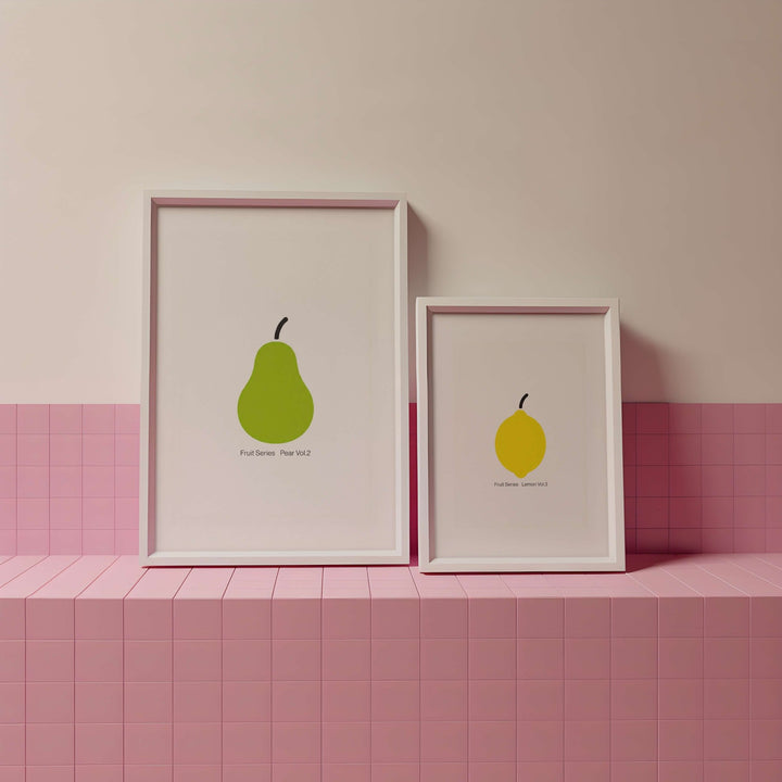 Two framed illustrations of pears on a pink tiled shelf against a pink wall.