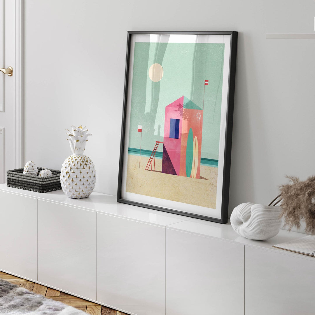 Abstract art print on a white wall above a white cabinet.