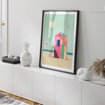 Abstract art print on a white wall above a white cabinet.