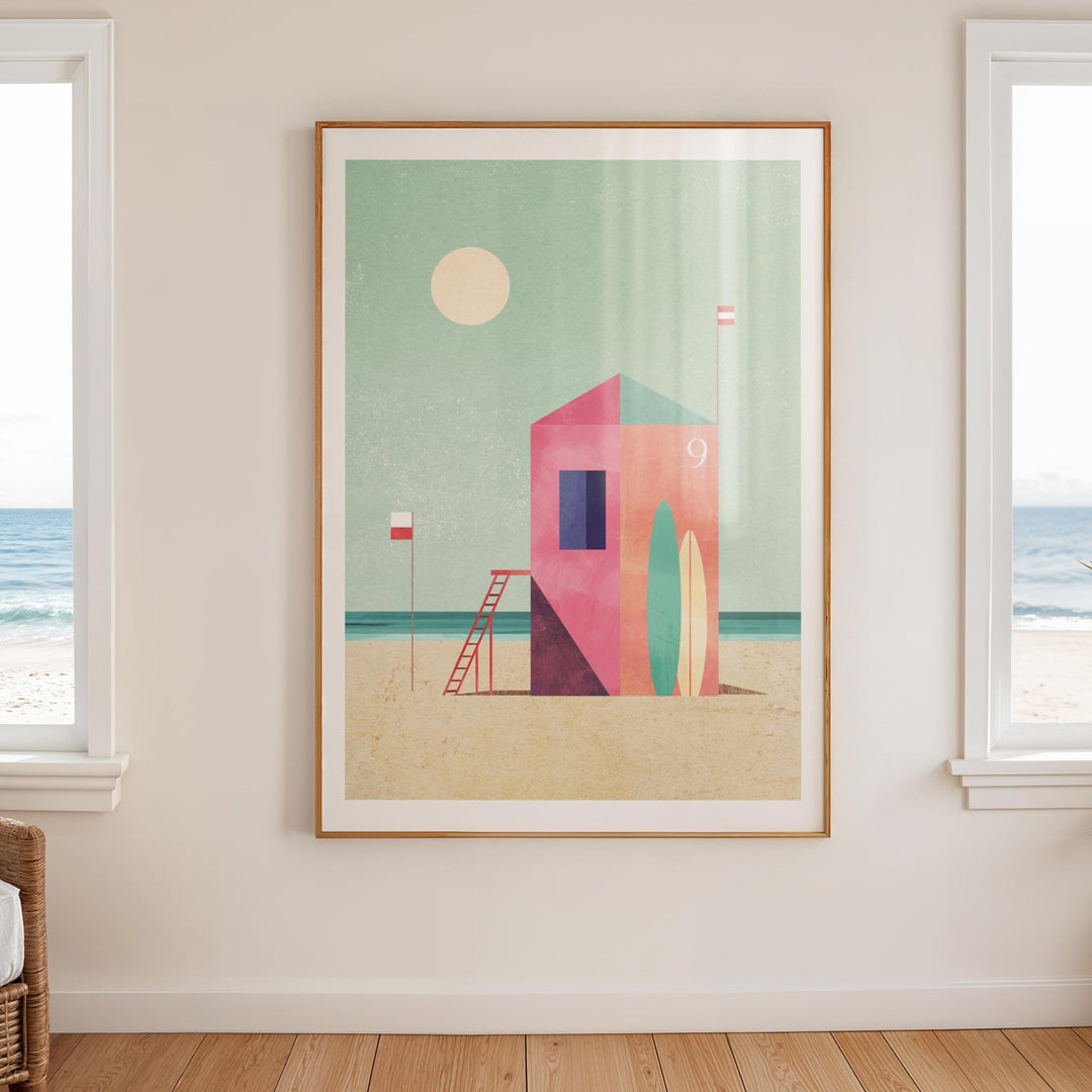 Artwork of a beach scene with a lifeguard tower on a wall with windows showing a view of the ocean.