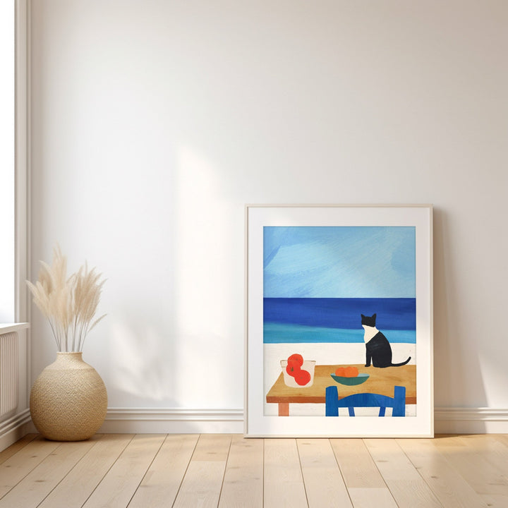 Artwork of a cat at a table by the sea on a white wall.
