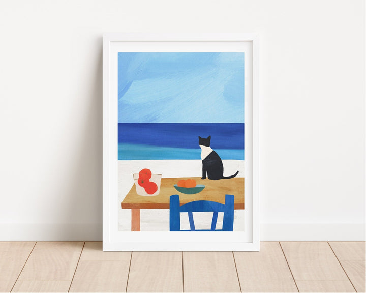 Artwork of a cat at a table with fruit, set against a blue sky and ocean.