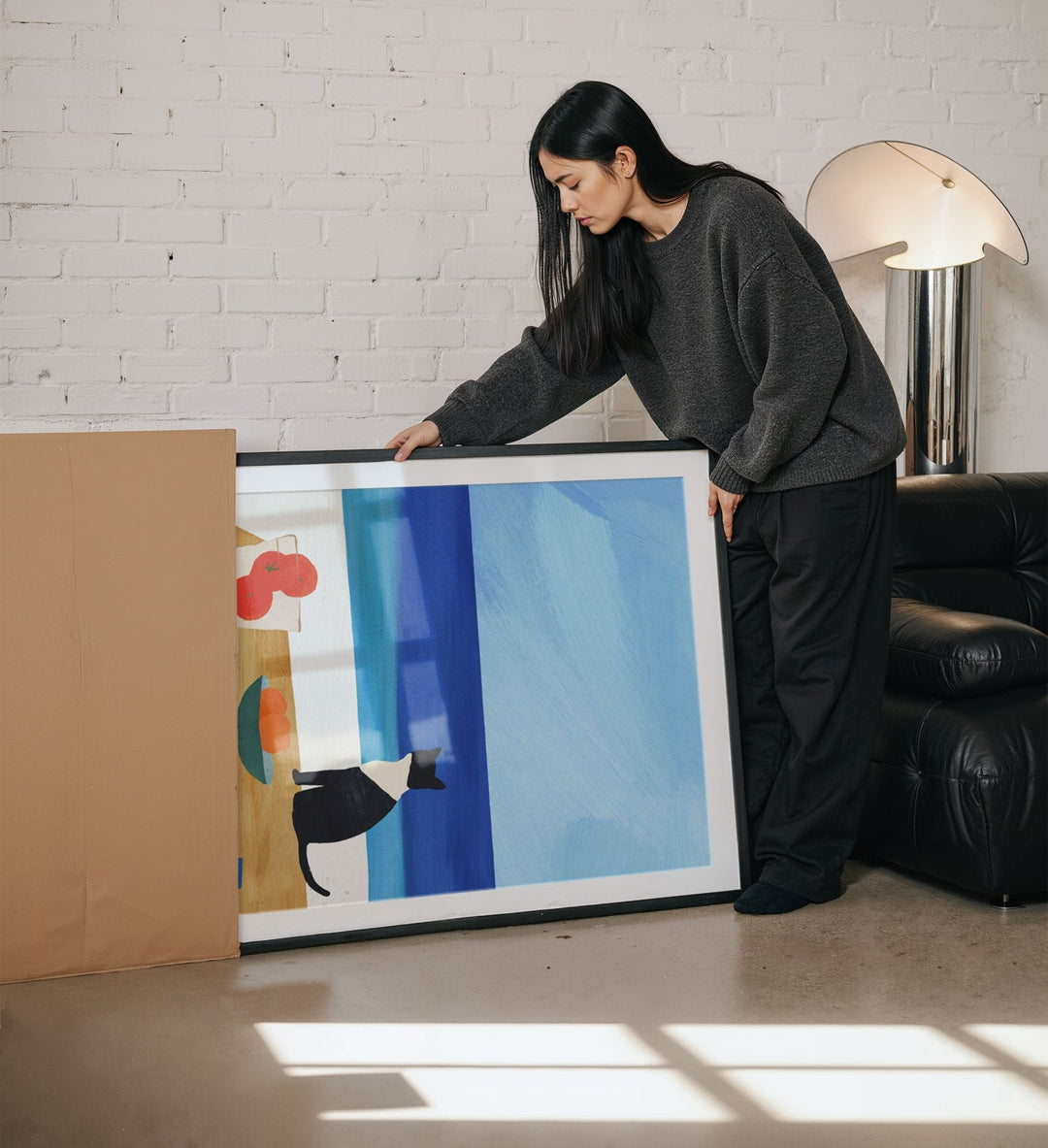 Woman holding abstract painting in a living room.