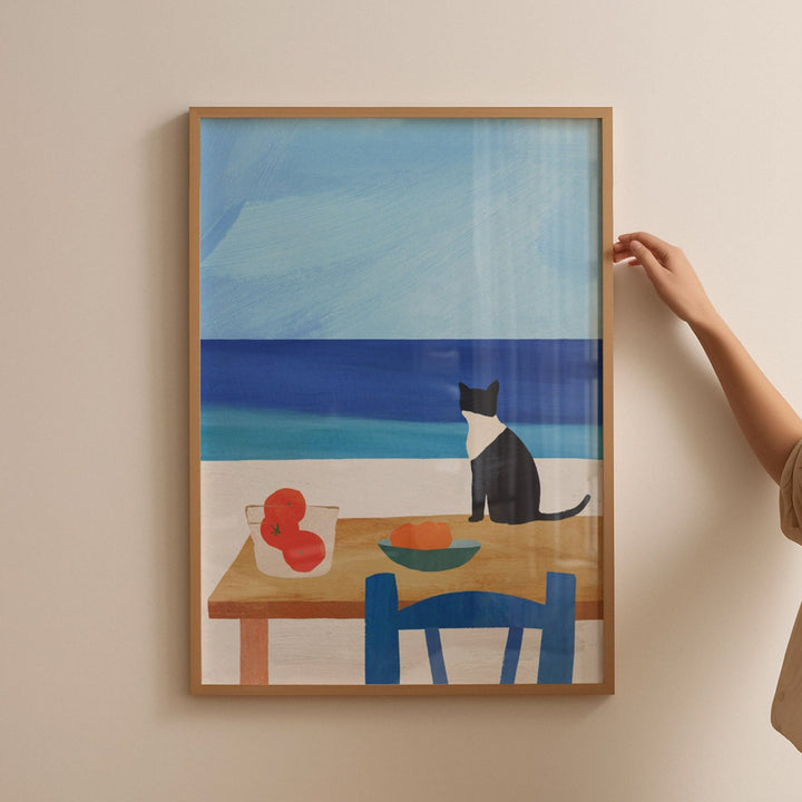 Artwork of a cat at a table with a blue wall background, held by a person.