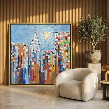 Canvas wall art with a gold leaf surround leaning against the wall in a luxe bedroom