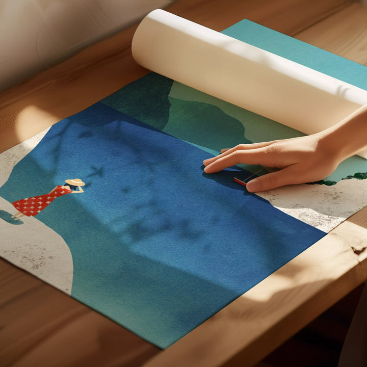 Person rolling out a large piece of paper with an illustration on a wooden surface