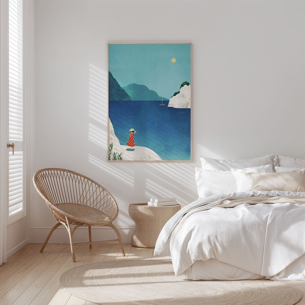Bedroom with a coastal painting on the wall, wicker chair, and bed.