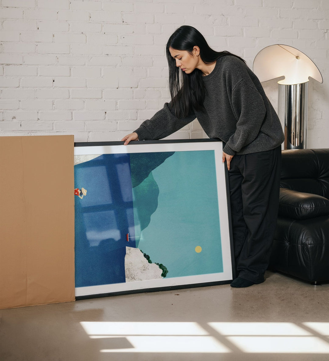Woman holding artwork in a living room.