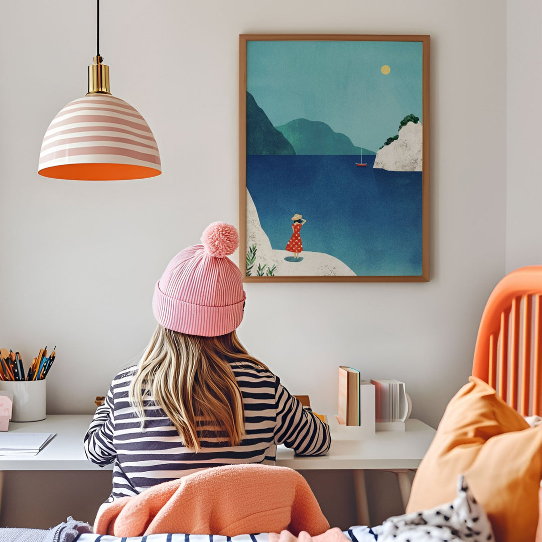 Person wearing a pink beanie sitting at a desk with a colorful painting on the wall.