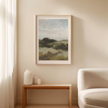 Landscape painting on a wall above a wooden side table with decorative items and a beige armchair.