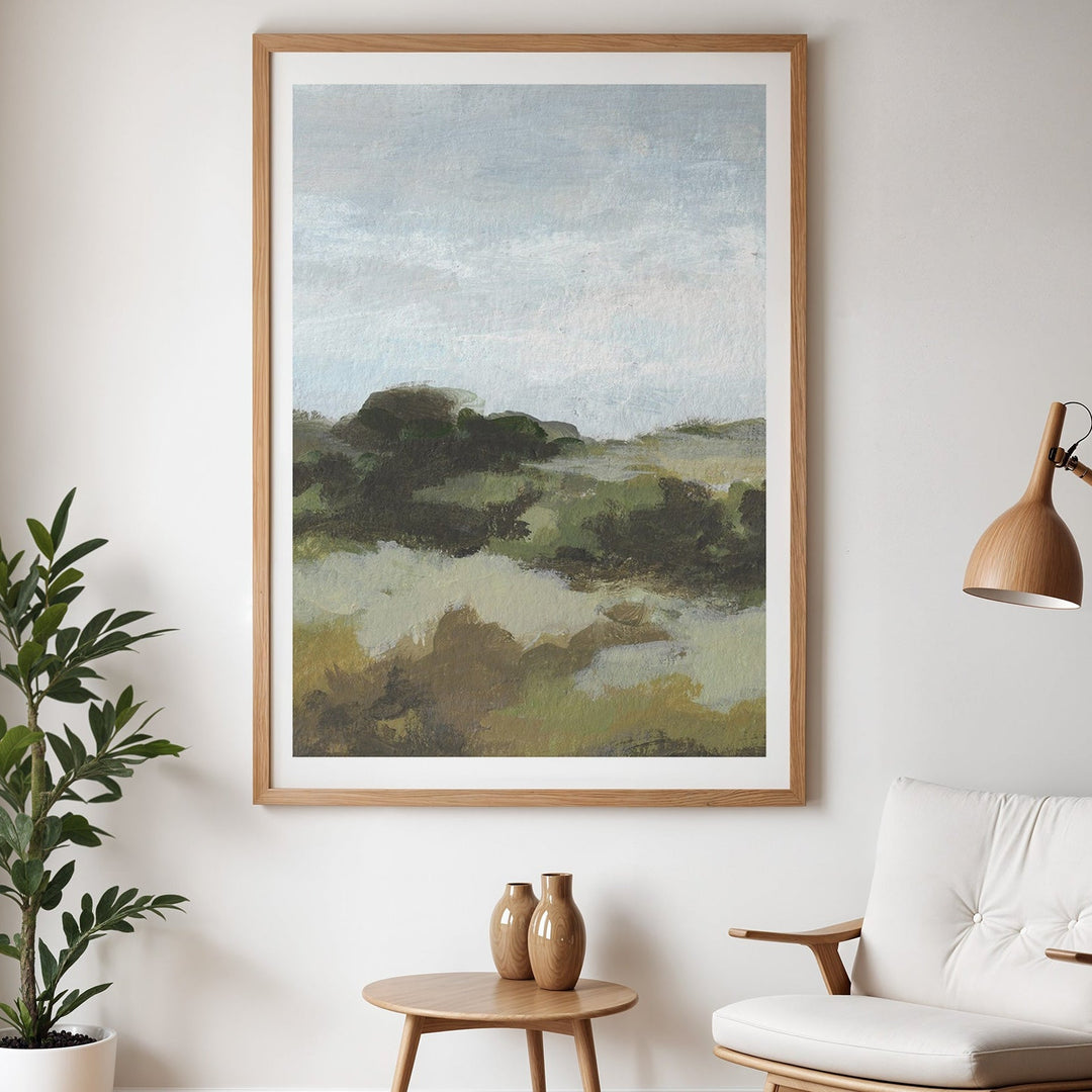 Modern living room with a landscape painting, armchair, side table, and lamp.