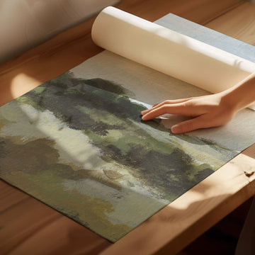 Hand rolling up a landscape painting on a wooden table