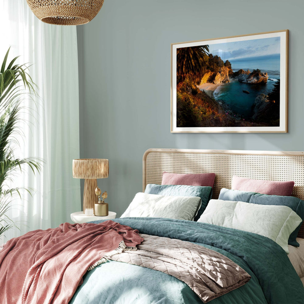 Bedroom with a bed, lamp, and picture of a coastal landscape.