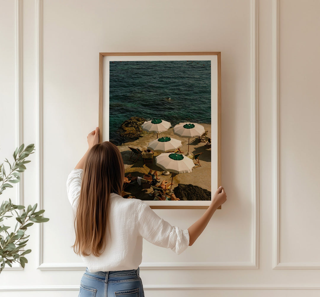 girl holding a print against white wall