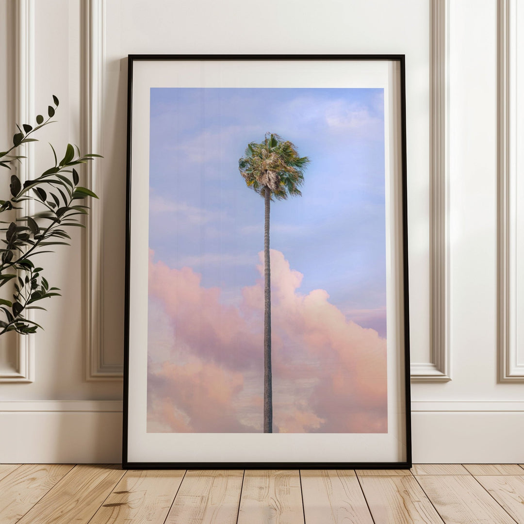 Artwork of a palm tree against a colorful sky on a wall.