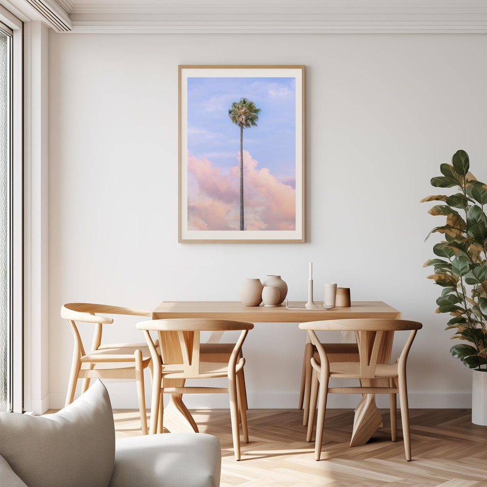 Dining room with wooden table and chairs, artwork of a palm tree, and a plant.