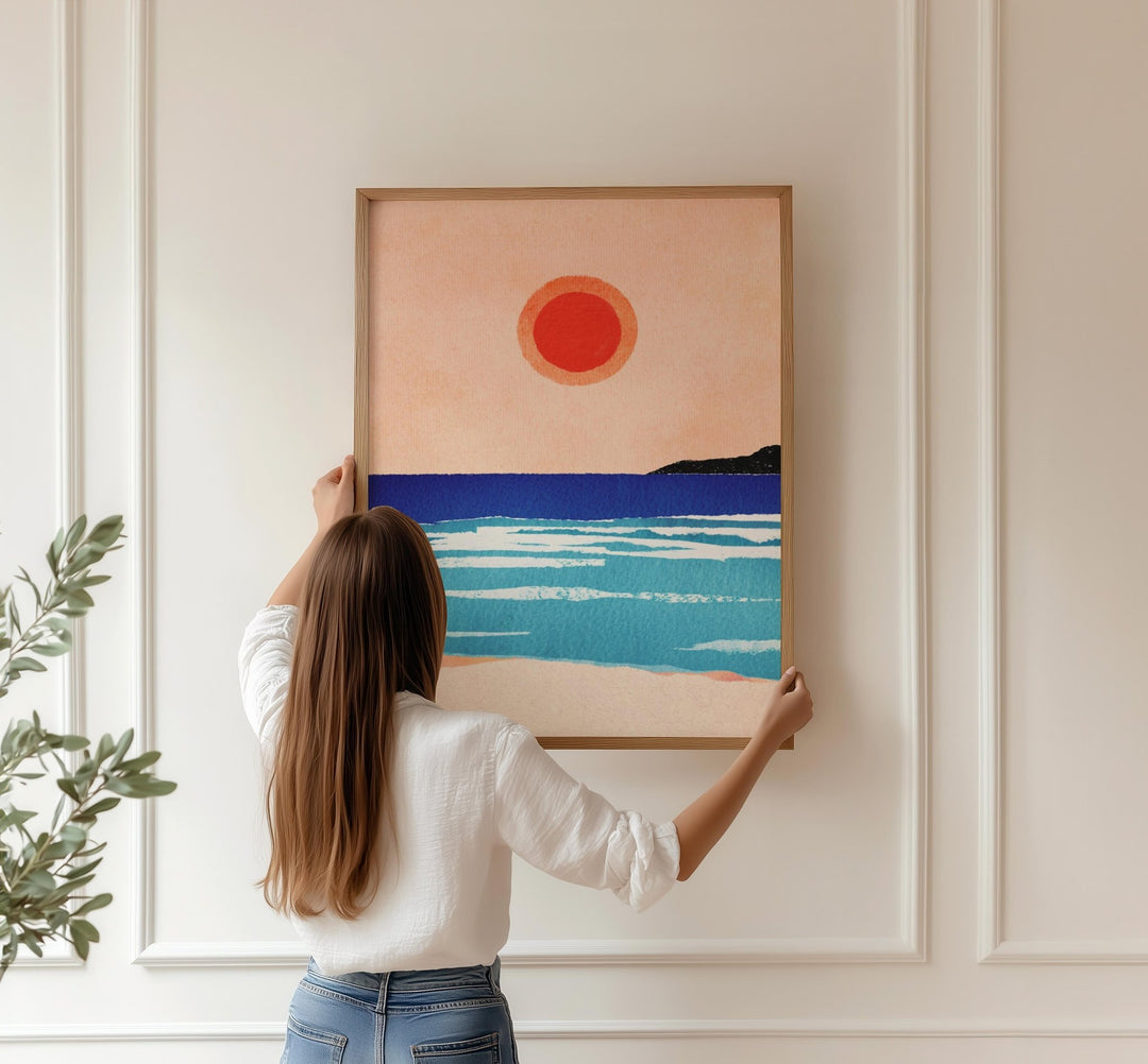 girl hanging artwork on white wall