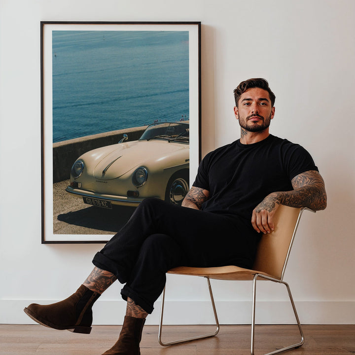 guy sitting on chair with photo of white car in the background