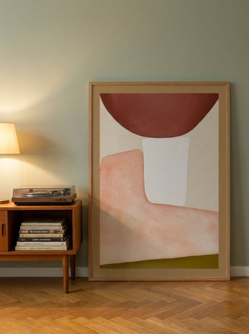 Oversized statement modern wall art print leaning against the wall in a mid-century dining room