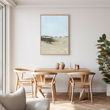Dining room with wooden table and chairs, artwork on the wall, and a plant.
