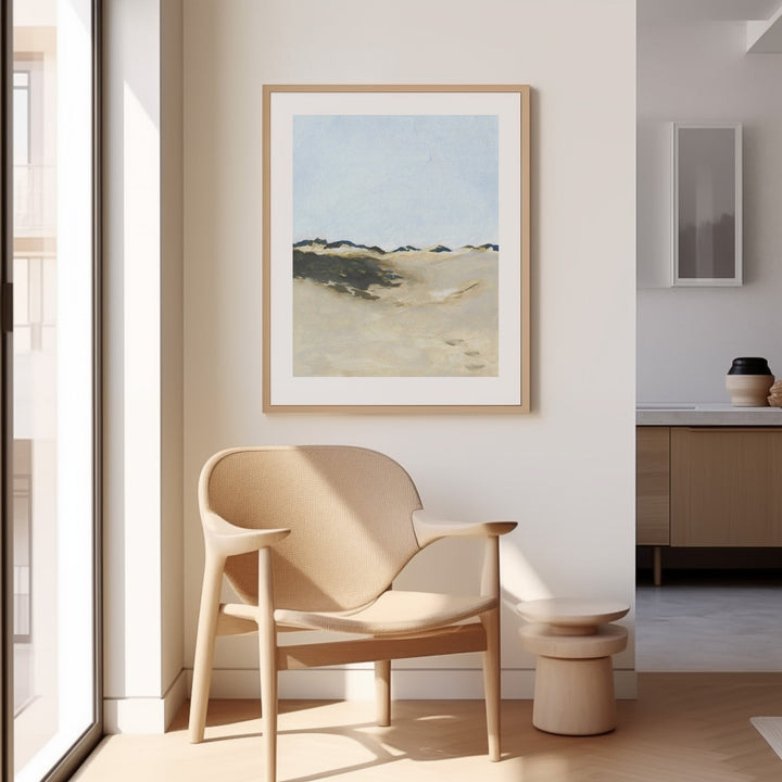Modern interior with a beige armchair, small table, and artwork on a white wall.
