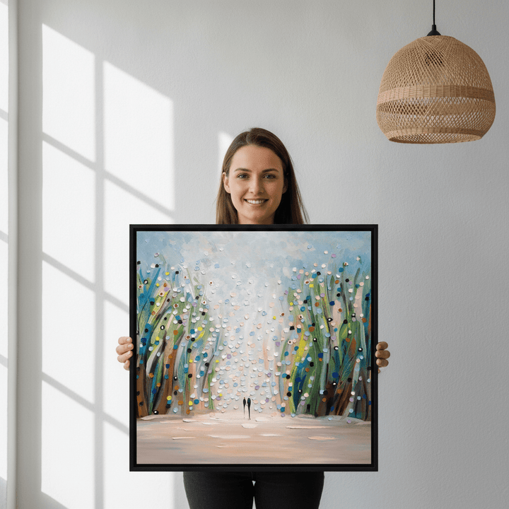 Person holding canvas wall art with a black surround in a bright Scandinavian living room