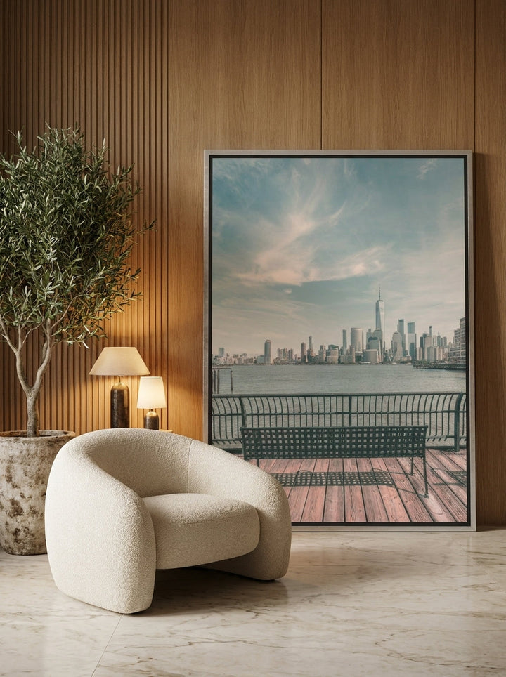 Oversized statement canvas wall art with a silver leaf surround leaning against the wall in a luxe living room