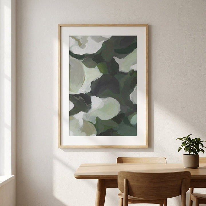 Abstract art print on a wall above a wooden table with chairs.