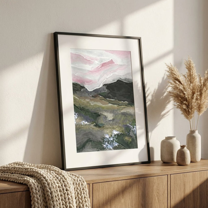 abstract landscape painting on a wall above a wooden cabinet with decorative vases and a textured blanket.