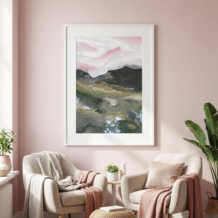 abstract artwork on a pink wall above two armchairs with cushions and blankets.