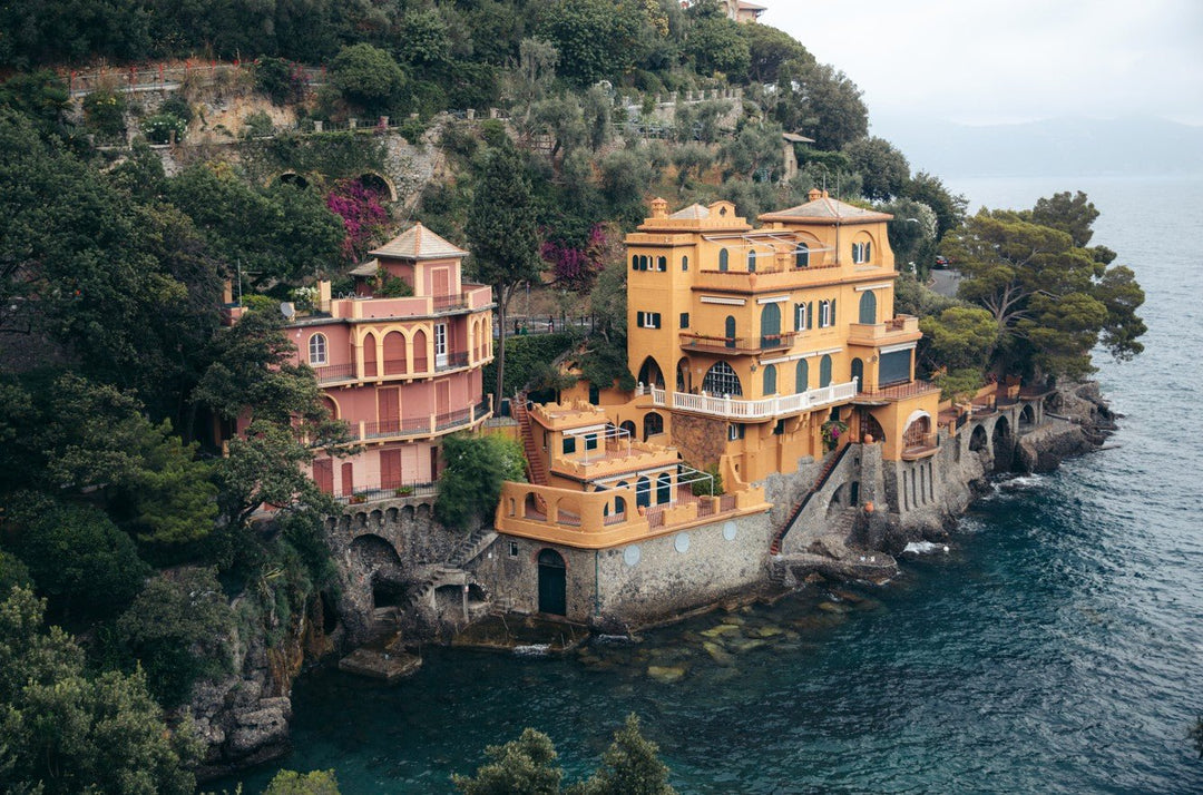 Luxurious villa on a cliff overlooking the ocean with lush greenery. framed