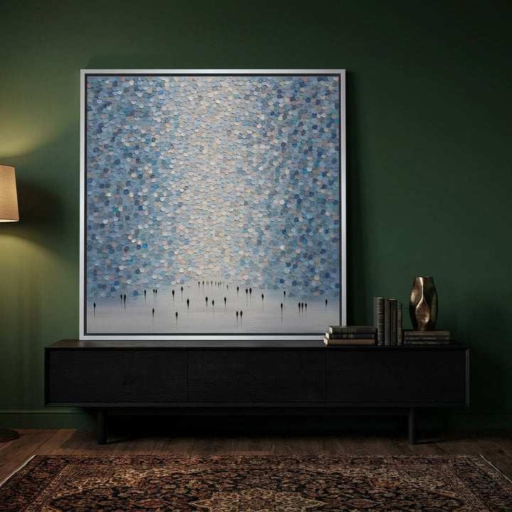 Canvas wall art with a silver leaf surround standing on a console in a moody living room