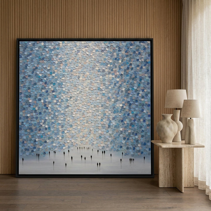Oversized statement canvas wall art with a black surround leaning against the wall in a luxe living room