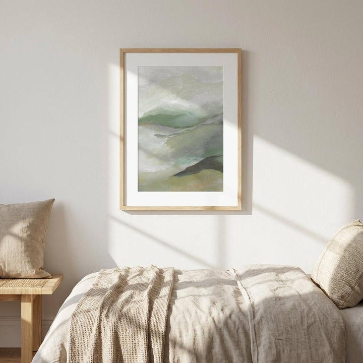 abstract art on a wall above a bed with natural light casting shadows.