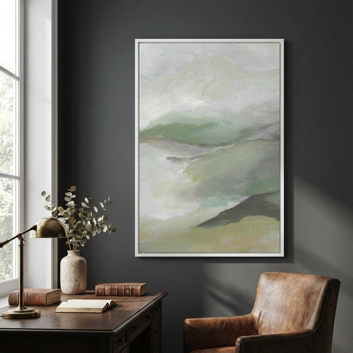 Abstract art on a dark wall above a desk with a lamp and books.