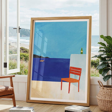 Abstract artwork with a blue sky and orange chair in a modern living room.