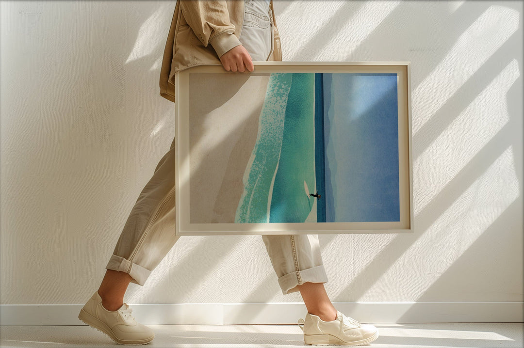 Person holding an artwork of a blue sky and green landscape.