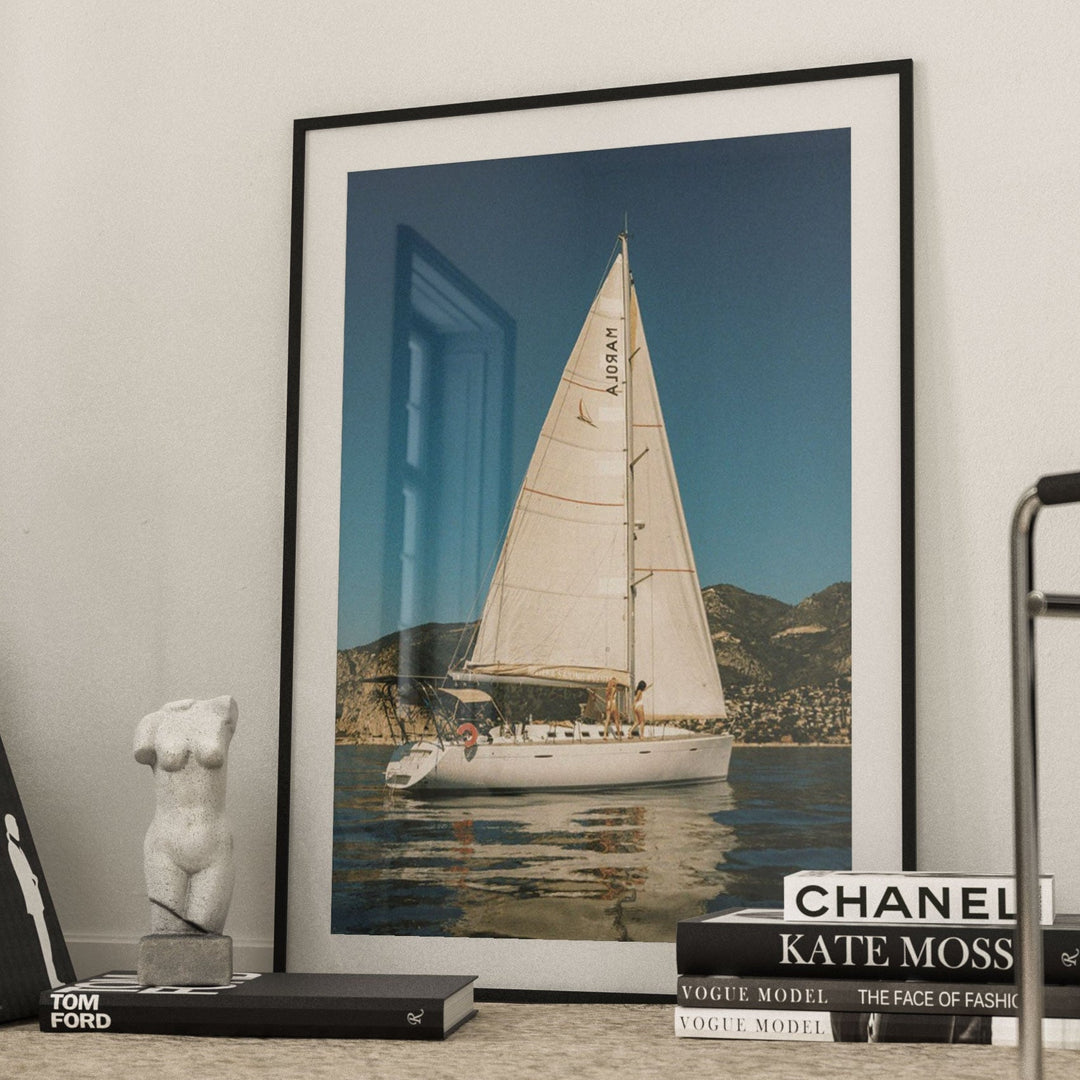 photo of sailboat on floor leaning against wall with books and figure on its side