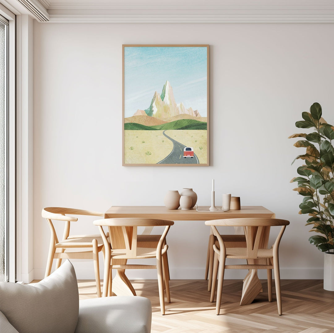 Dining room with wooden table and chairs, artwork on the wall, and a plant.