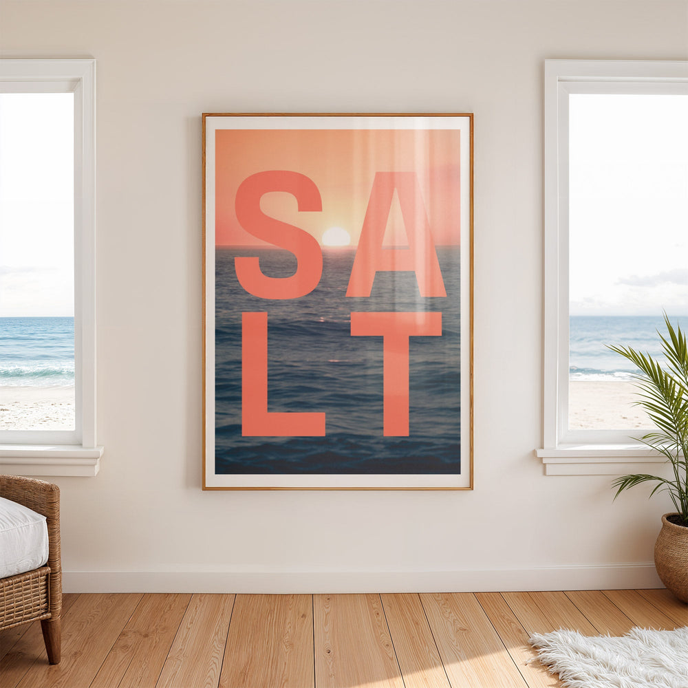 Artwork with 'SALT' text and ocean design on a wall with windows showing a beach view.