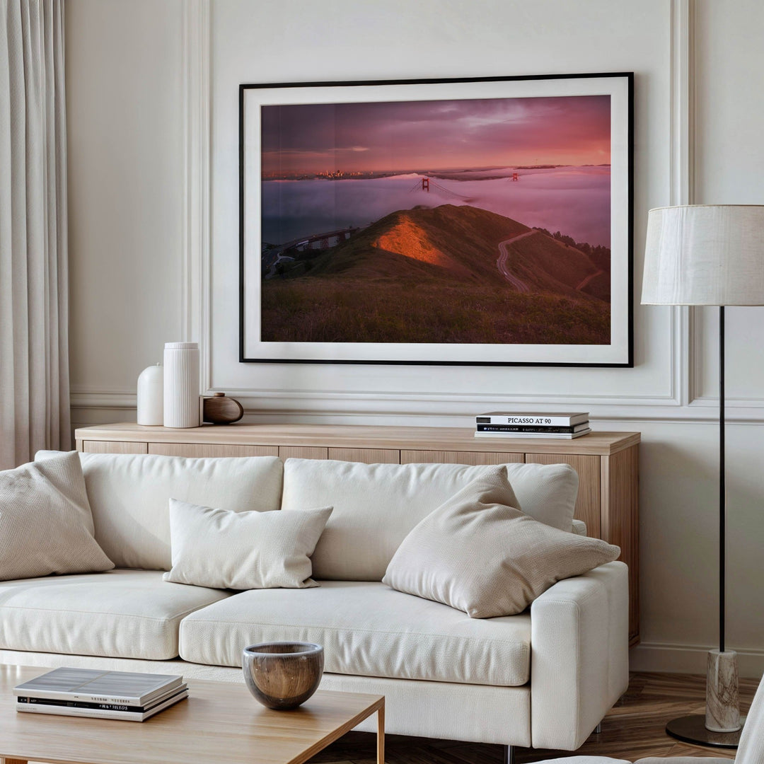 Living room with a white sofa, wooden coffee table, and a large picture on the wall.