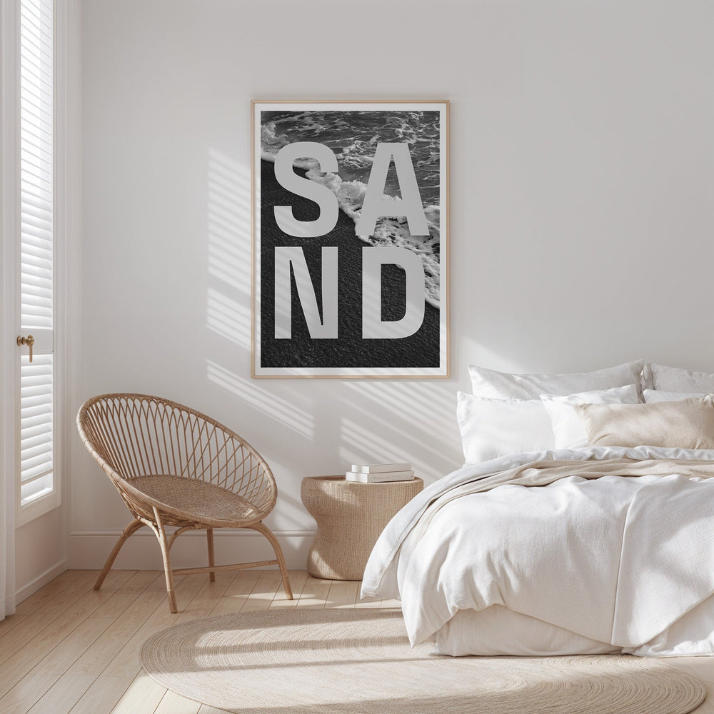 Modern bedroom with a 'SAND' artwork on the wall.